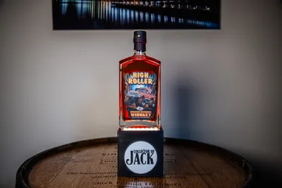 High Roller Straight Bourbon Whiskey on top of a whiskey barrel